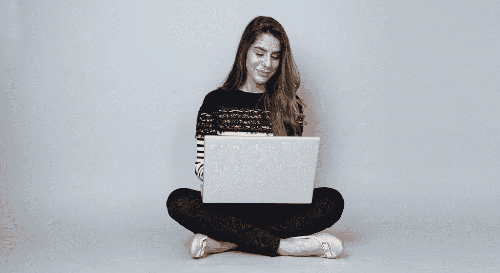 Foto van een zittende vrouw met laptop op schoot