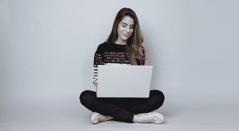Foto van een zittende vrouw met laptop op schoot