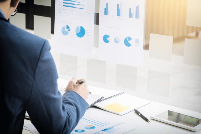 Foto van een man aan het werk met tal van grafieken voor zijn neus